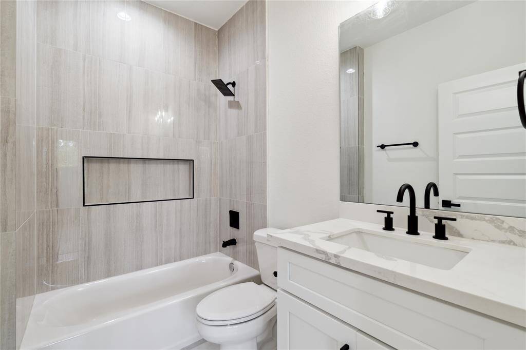 The secondary bathroom is beautifully designed with modern finishes, offering a clean and functional space for family or guests. It features sleek fixtures and thoughtful details that complement the home’s overall style.