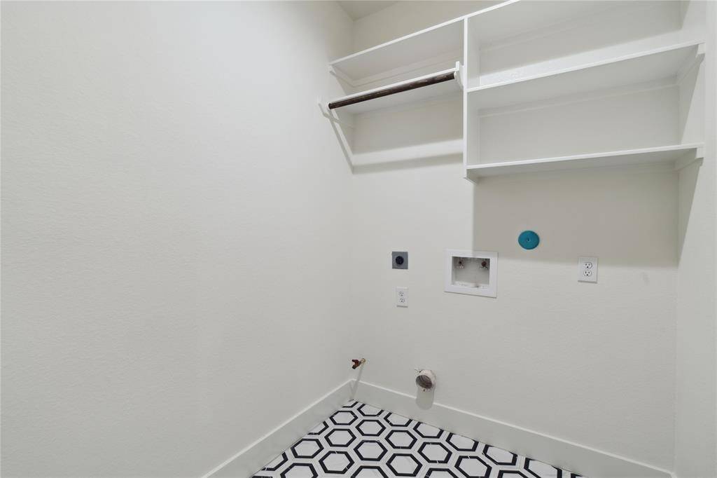 The large utility room on the third floor is conveniently located next to the bedrooms, featuring beautiful tile and built-in shelves for easy storage. It’s both practical and stylish, making laundry a breeze