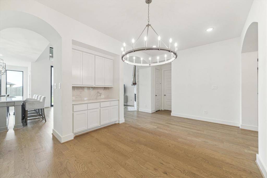 The Formal Dining room has the WOW factor and the built in butlers pantry gives you plenty of additional counter space. The crown chandelier is the focal point of the room and the continuous hardwood floors continue through this area.