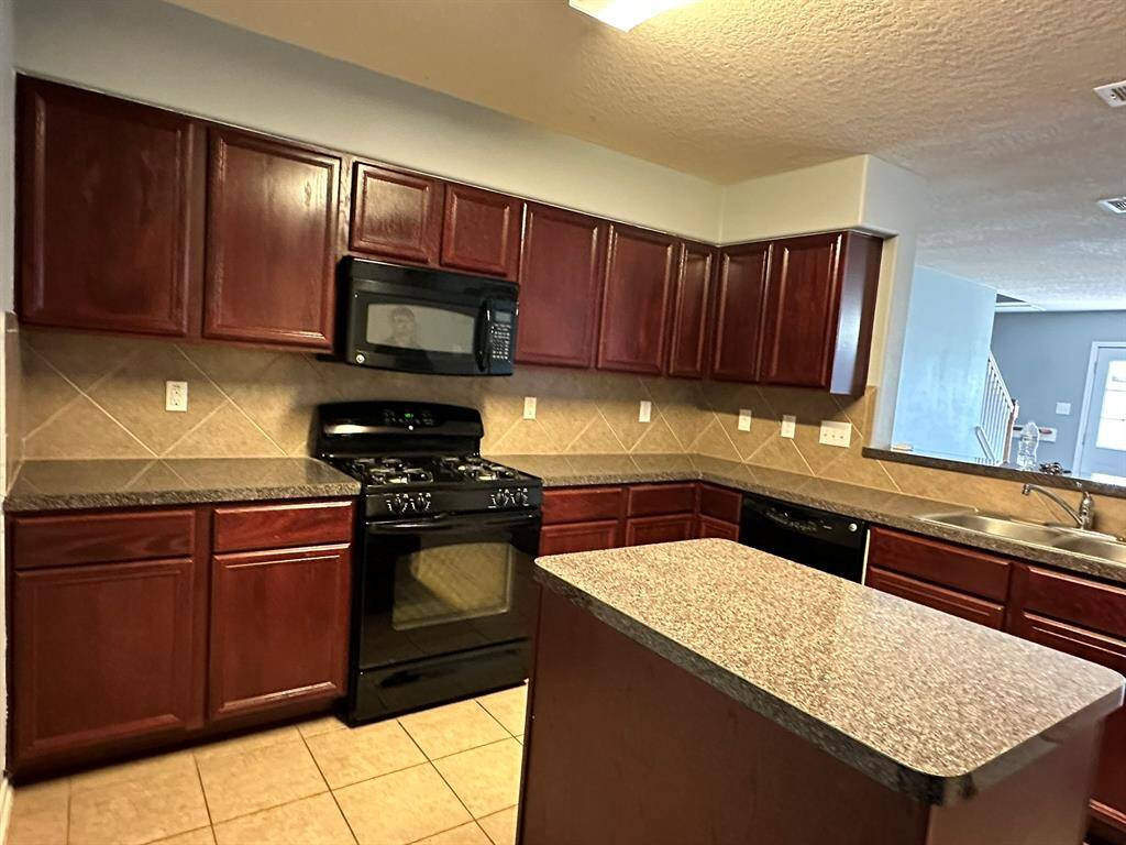 Open kitchen to living area. Has island.