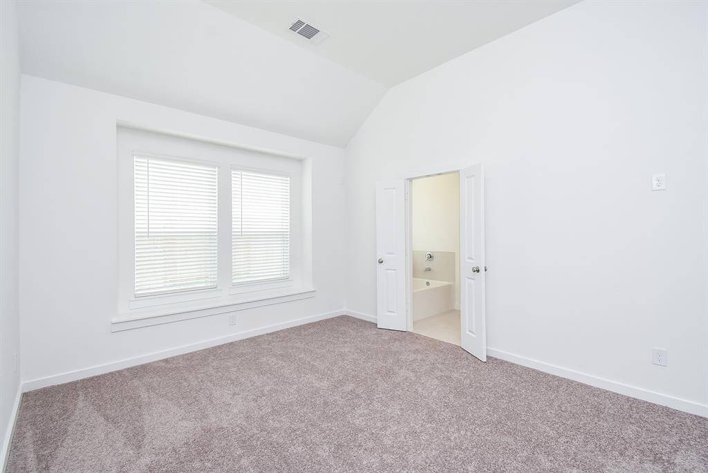 High ceiling, earth toned carpeting, double windows and wall and floor space, galore, fill your primary suite.