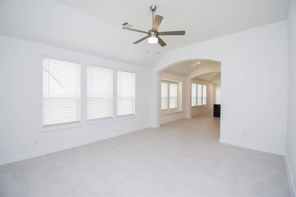 This grand living area is also naturally lit, while a high ceiling, generous wall and floor space, and wide arched doorway naturally connect living, dining and kitchen space, ahead.