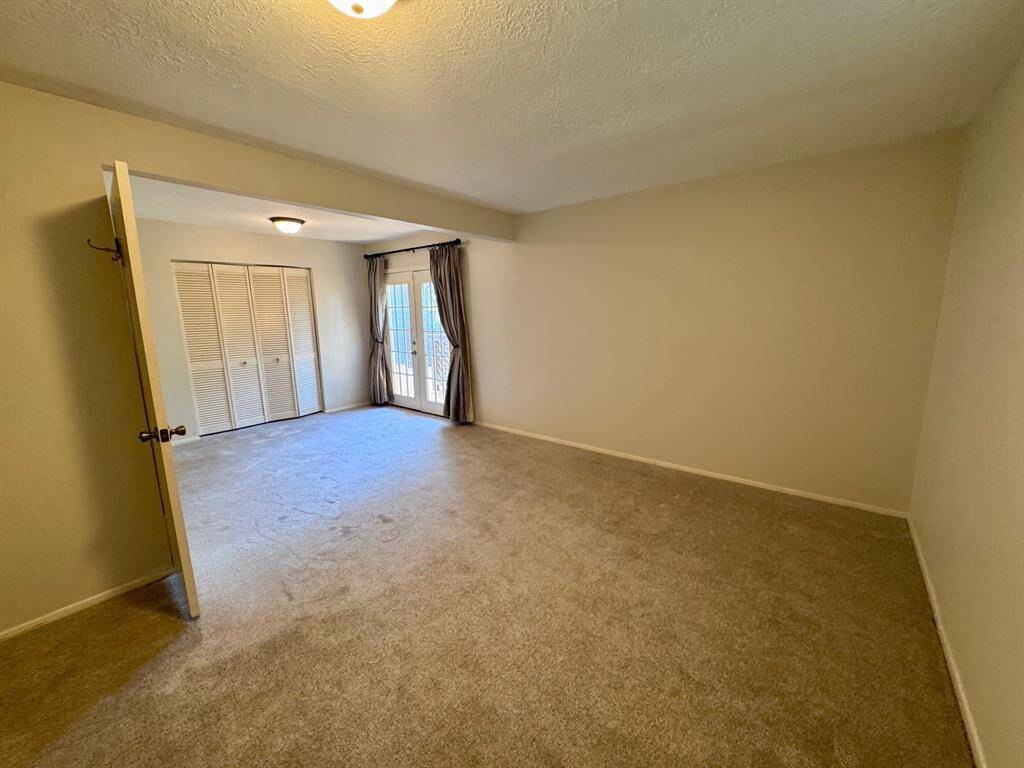 Secondary bedroom features new carpet that has never been lived on before!  The French door leads to the beautiful back yard.
