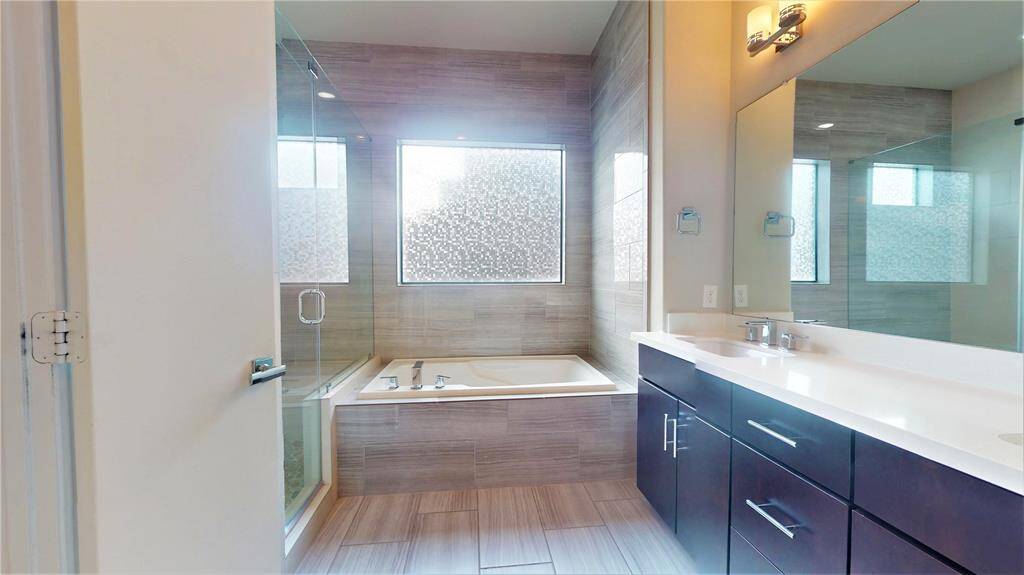 Primary bathroom... notice the shower to the left with its frameless shower enclosure...