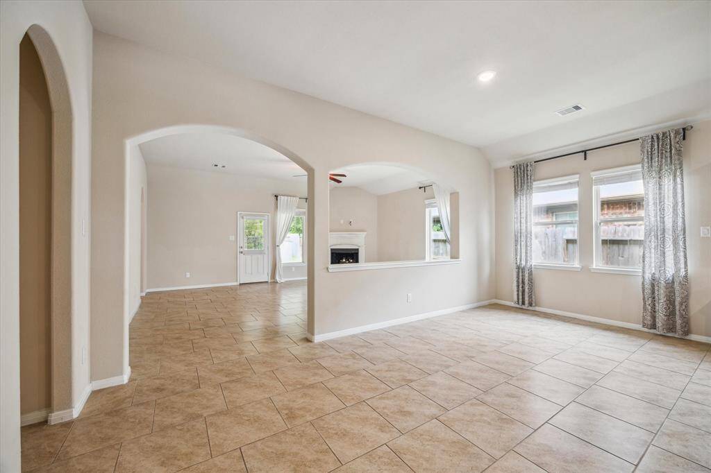 Bright and open breakfast/dining area with elegant tile flooring and abundant natural light, perfect for family meals and entertaining.