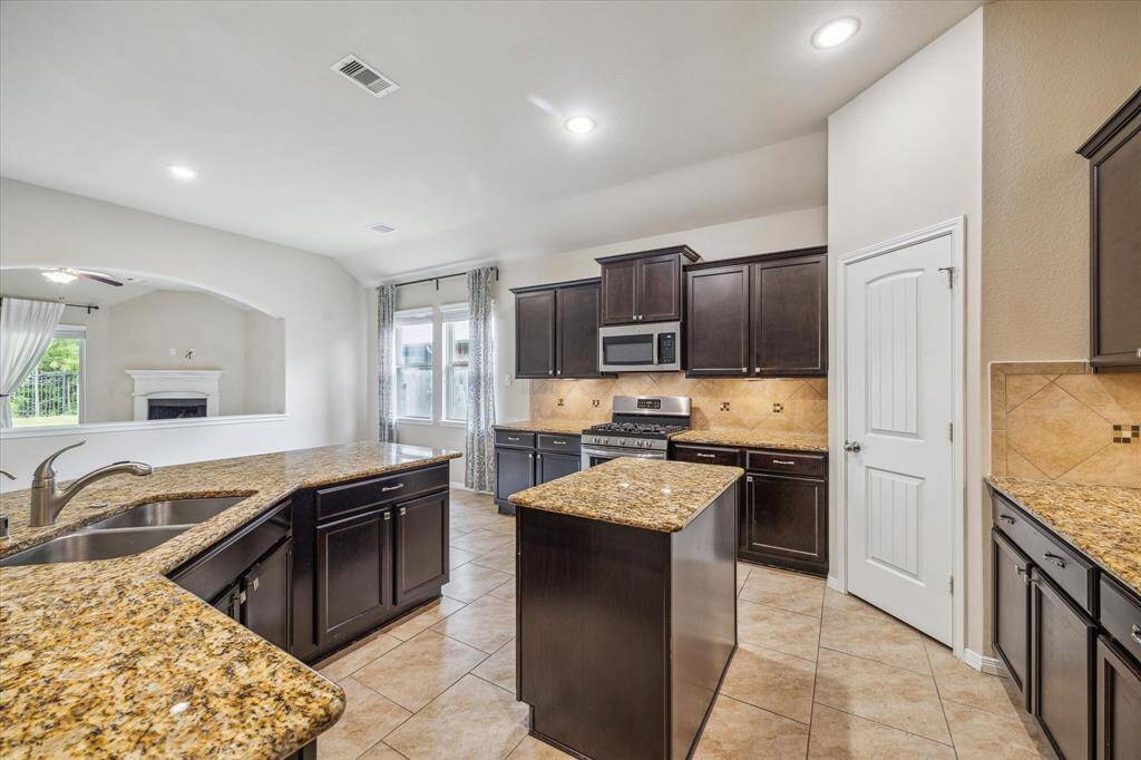 Spacious chef's kitchen with a central island, perfect for culinary enthusiasts.