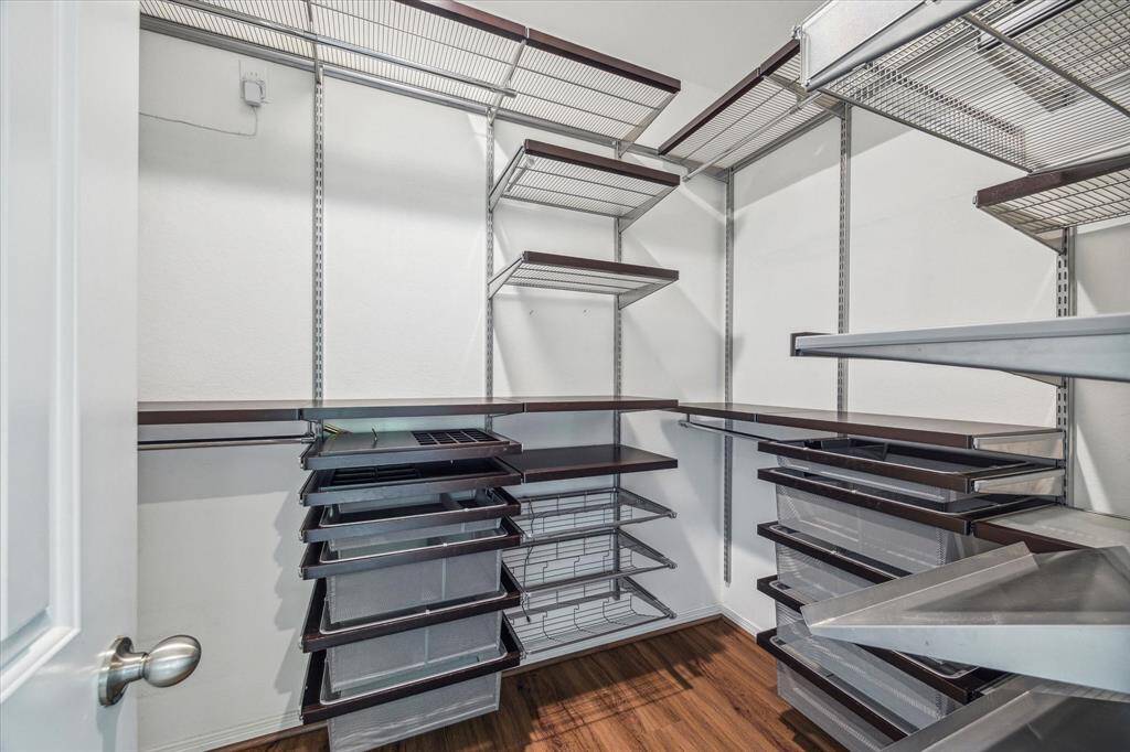 Expansive primary closet with customizable shelving and sleek, modern design. Perfect for organizing your wardrobe effortlessly.