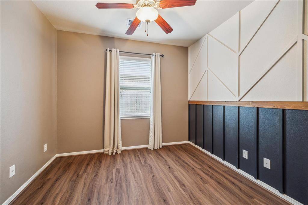 Secondary bedroom featuring elegant wall molding enhances the room's modern charm.