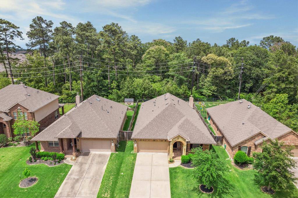 Charming suburban homes with well-maintained lawns, situated along a tree-lined street. The backyard offers privacy, bordered by lush greenery and mature trees. Ideal for families seeking a peaceful neighborhood.