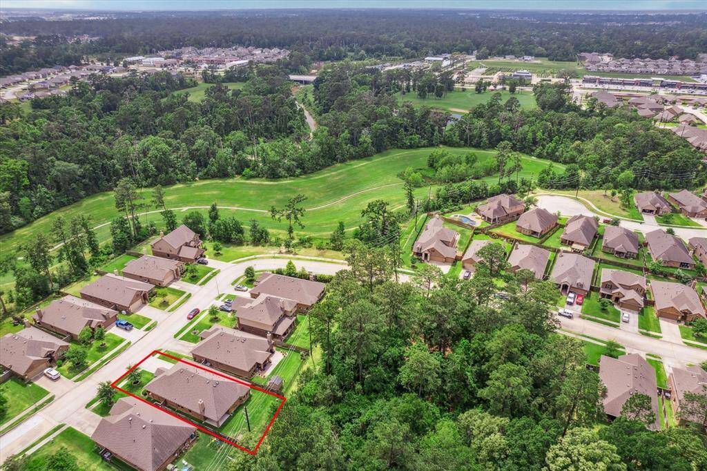 This aerial photo showcases a serene neighborhood with well-maintained homes surrounded by lush greenery. The highlighted property is situated on a quiet street of 10 homes, offering ample privacy and scenic views. Ideal for those seeking a peaceful residential area with close proximity to nature.