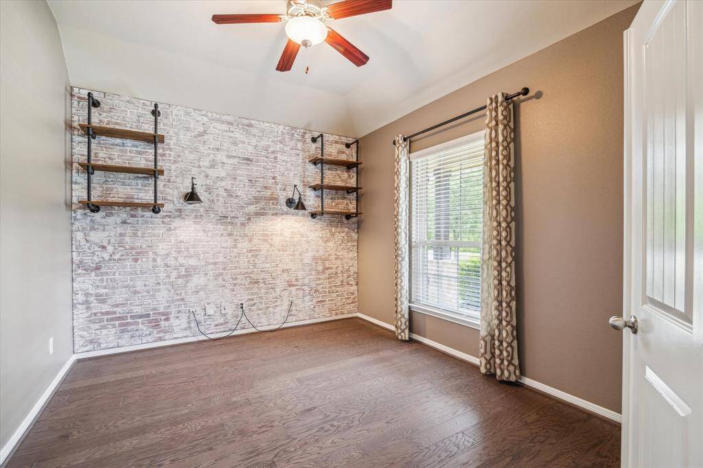 Versatile flex space with stylish sconces, built-in shelving, and ample natural light—ideal for a home office or creative studio.