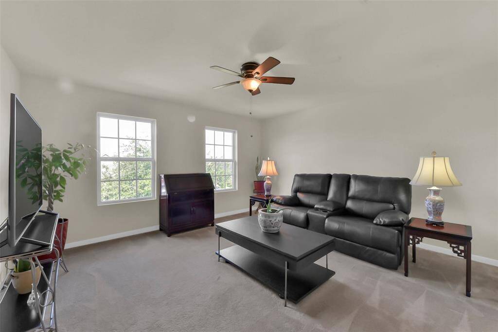 Upstairs, find a good-sized living area with plenty of windows, currently a comfortable spot for TV and lounging, but also perfect for a game room!