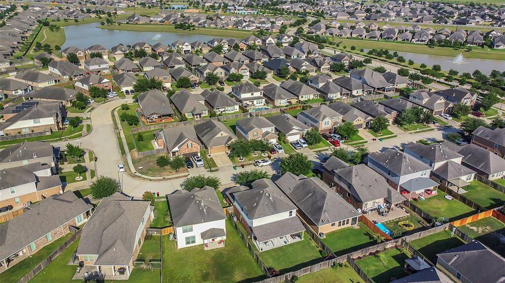 This breathtaking drone image reveals a serene and picturesque neighborhood nestled beside sparkling lakes. The tranquil waters reflect the lush greenery and the well-planned community, creating a harmonious blend of nature and residential living. The quiet ambiance of the area is palpable, promising a peaceful retreat for its residents