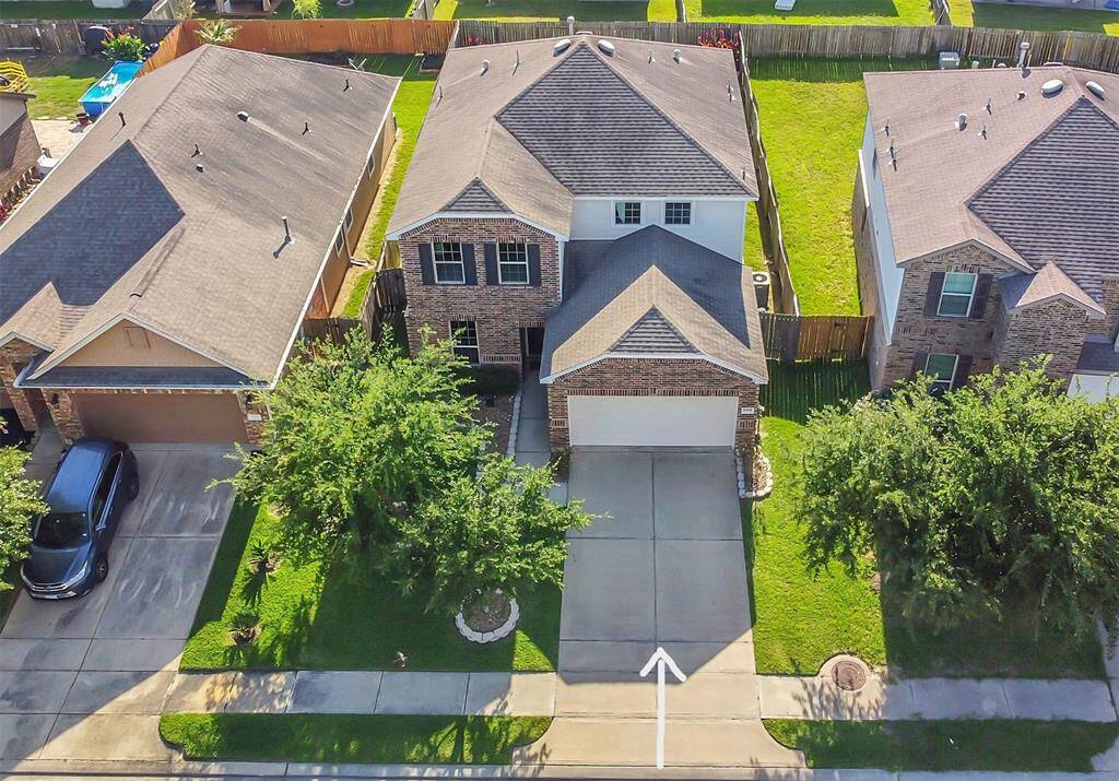 Drone view showing the home and its position between two neighboring houses