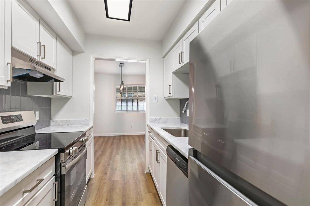 Sleek kitchen seamlessly connected to the laundry room, offering convenience and style.