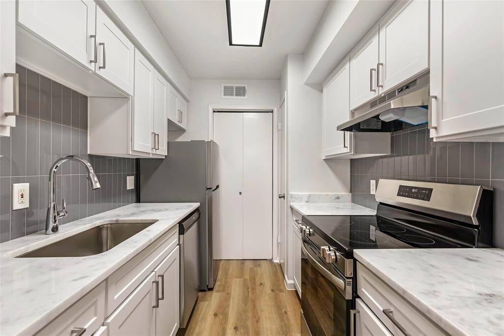 Discover the elegance of a remodeled kitchen featuring quartz countertops and new stainless steel appliances.