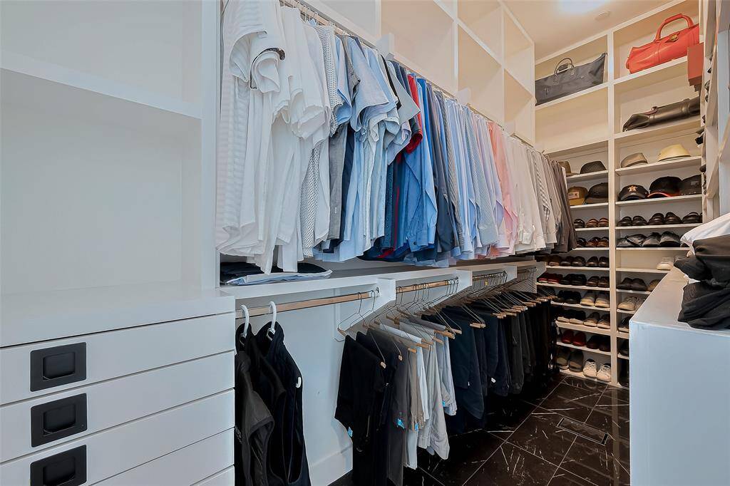Primary Closet with custom built shelving and drawers for organiztion