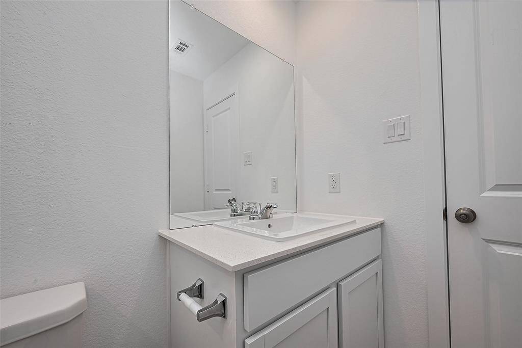 Single vanity with quartz counter tops.
