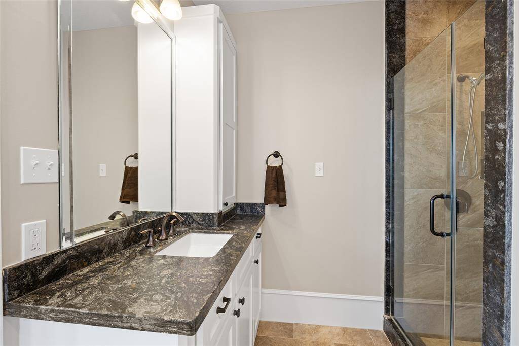 Primary bath with large updated walk-in shower and beautiful granite counters.