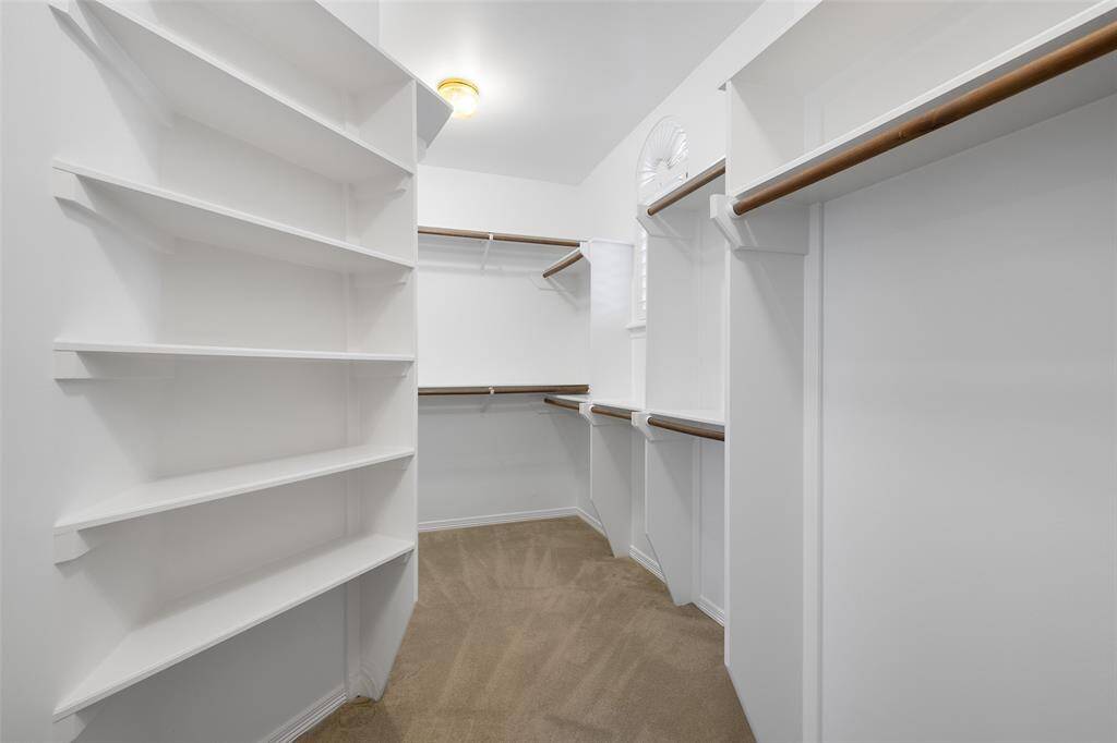 Large walk-in closet with entrance from primary bathroom.