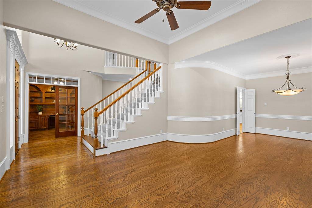 Another view of the living room with entryway.  Love the architectural and custom details in this home including wainscoting, chair railing and crown molding as well as arched and tray ceilings.