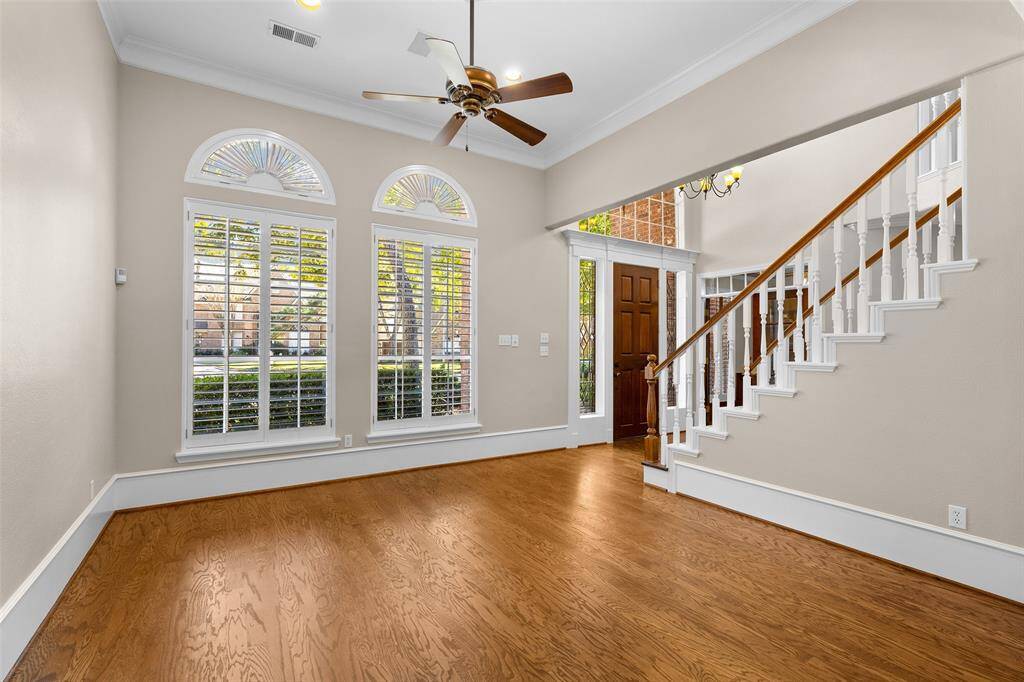 Natural light fills the living room through stunning arched windows with plantation shutters.