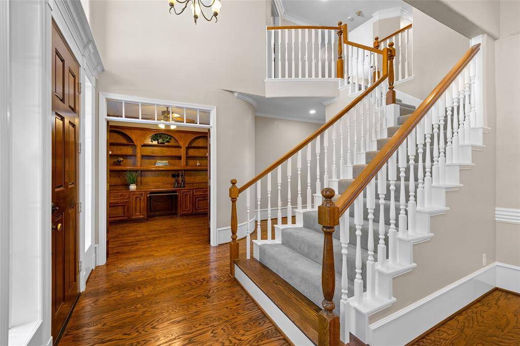 Another view of entrance with elegant wooden staircase and door to the study.  Love the beautiful flooring providing warm and inviting atmosphere.
