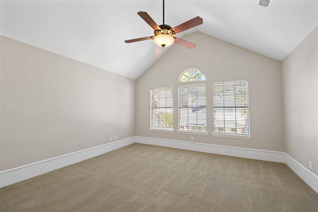 Natural light streams through windows in upstairs game room with vaulted ceiling.