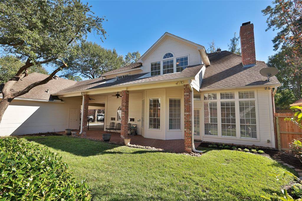 Inviting covered porch nestled in a well-maintained yard with mature trees.