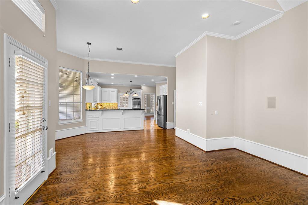 Another view of fabulous living space with beautiful wood flooring and breakfast bar.