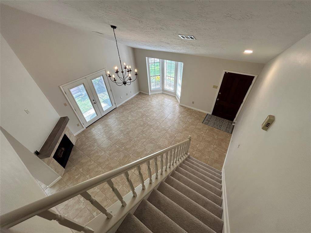 View from top of stairs to main living/family room and front door