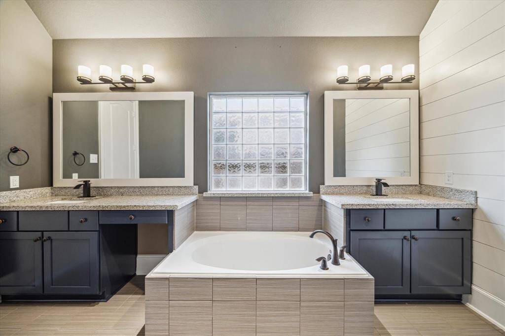 This view of the primary bathroom highlights a designated vanity area and eye-catching accent walls—adding both style and functionality to your daily routine.