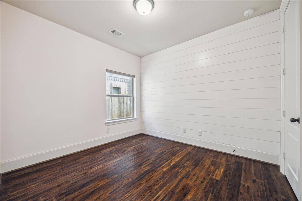 This secondary bedroom offers comfort and style, featuring its own unique accent wall that adds personality and a custom feel to the space.