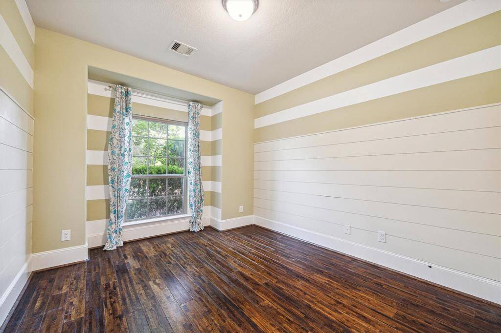 Another secondary bedroom filled with natural light, showcasing a playful yet refined color scheme on the accent walls—perfect for adding character and charm.