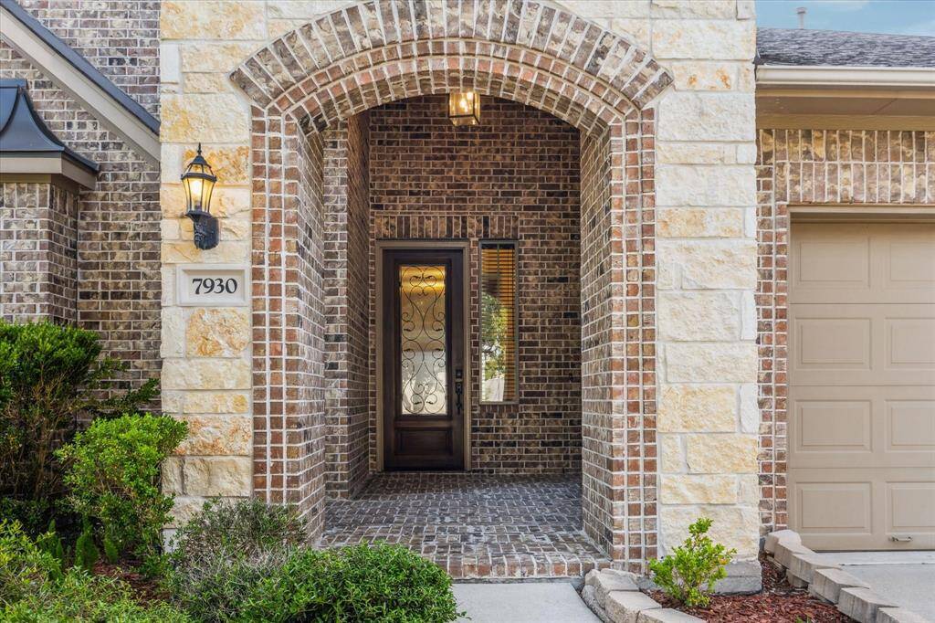 Step up to the elegant entryway, where timeless brick and stone detailing create a warm, welcoming first impression.