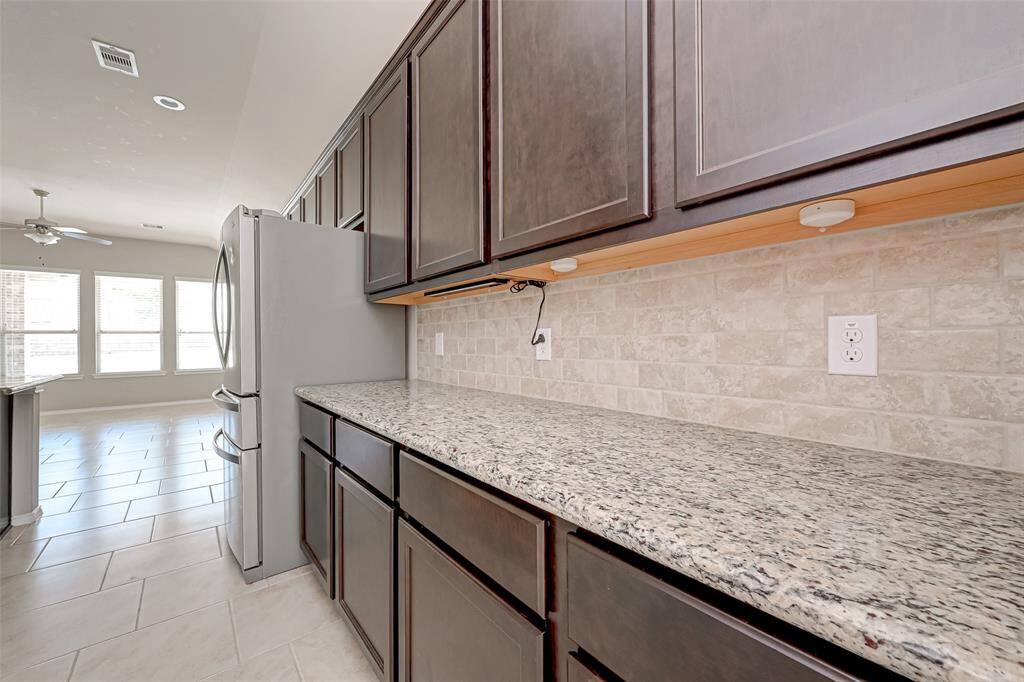 The countertops have been carefully chosen to complement the brown cabinetry, creating a harmonious and visually pleasing atmosphere.