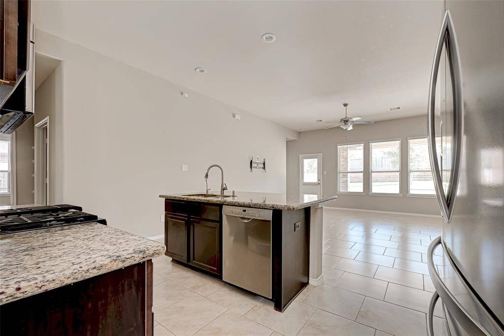 The heart of this kitchen is the center island that not only provides a spacious and dedicated workspace but also features a convenient sink.