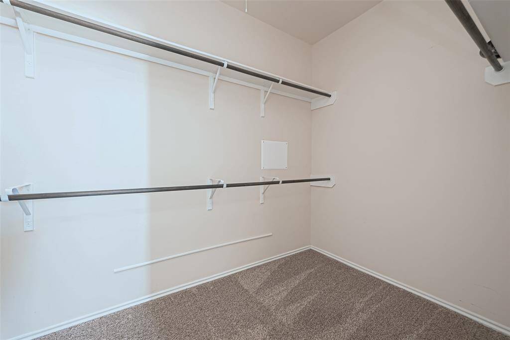 This walk-in closet has multiple hanging racks provide a designated space for your clothing items, keeping them wrinkle-free and easy to access. Showcase your designer dresses, suits, and statement pieces effortlessly.