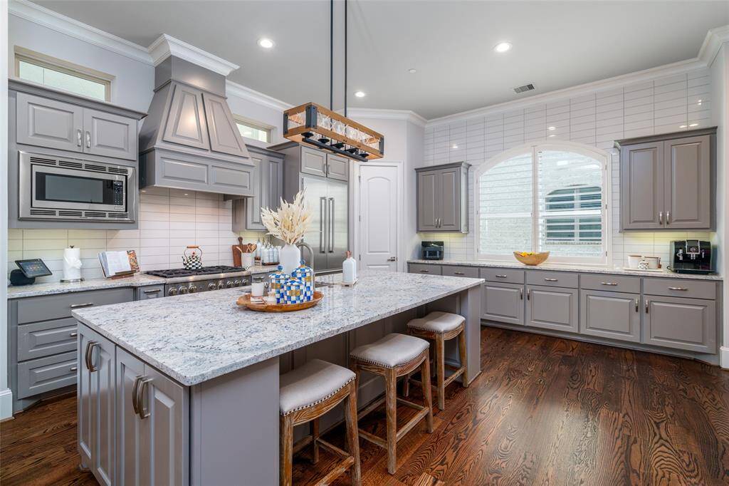 Experience culinary luxury in this sunlit gourmet kitchen, featuring premium appliances, a spacious island, and generous counter space.