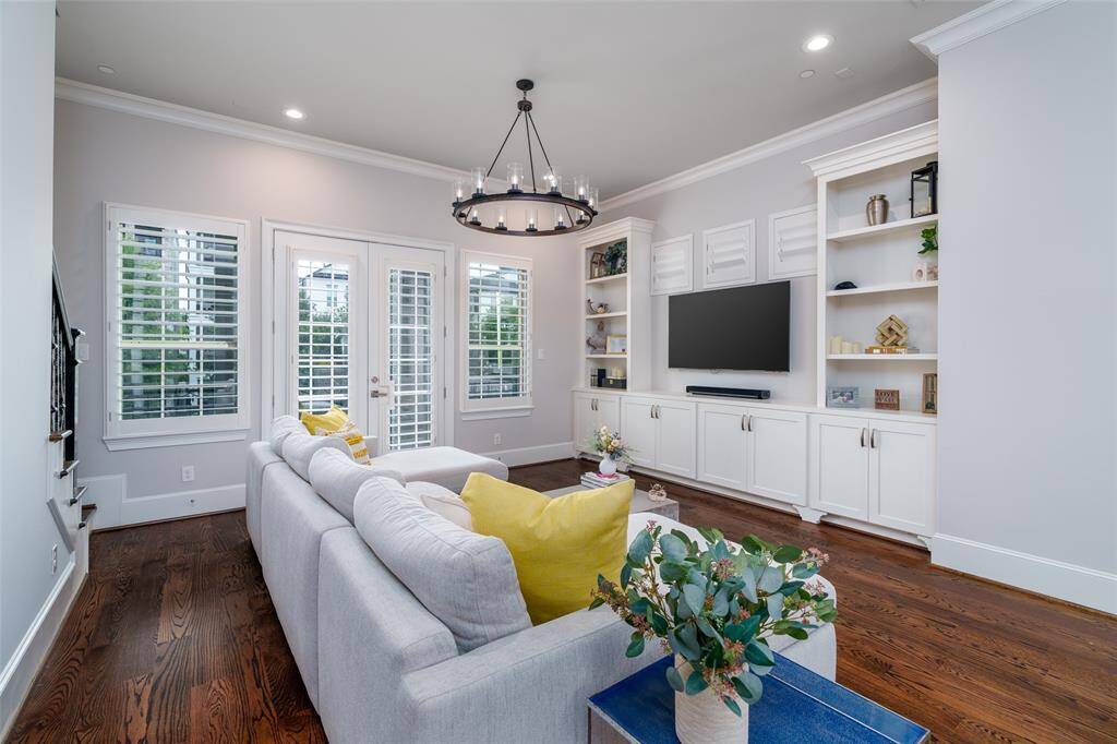 Spacious living room with a sunlit balcony offering stunning canal views and elegant shutters.