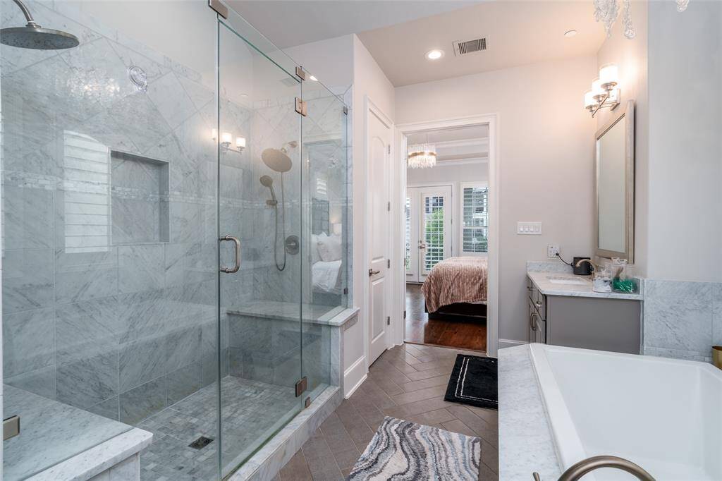 The large vanities and additional linen closet allow for ample storage in this primary bathroom.