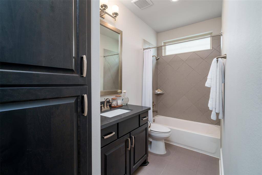 This elegant full bath on the fourth floor serves the bedroom and game room, offering ample storage.