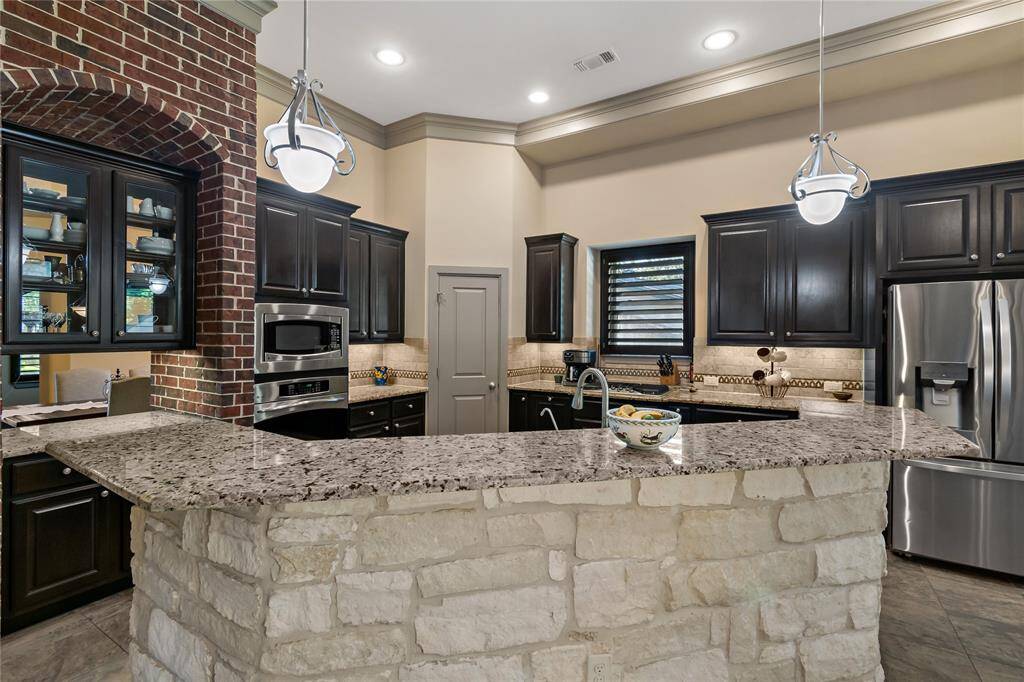 Amazing well-appointed kitchen with stainless appliances including built-in oven and microwave. Refrigerator stays. Plenty of seating area at island if desired