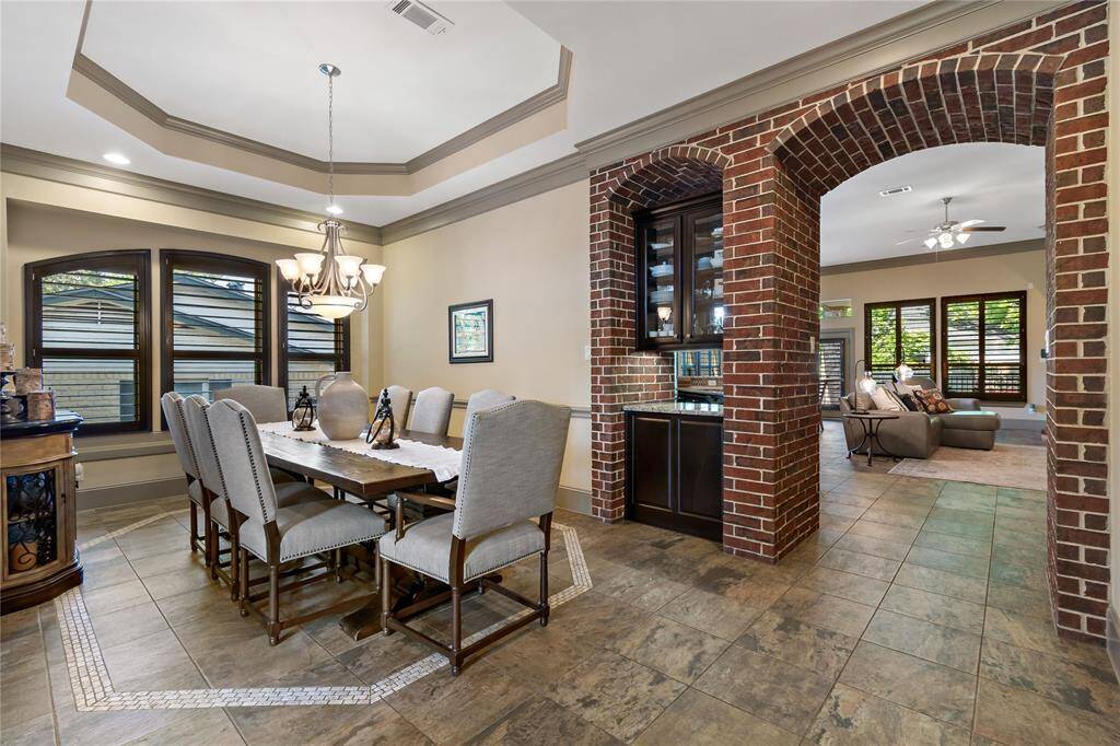 Step from the office into the large dining room with tray ceiling. Notice the butler's serving area.