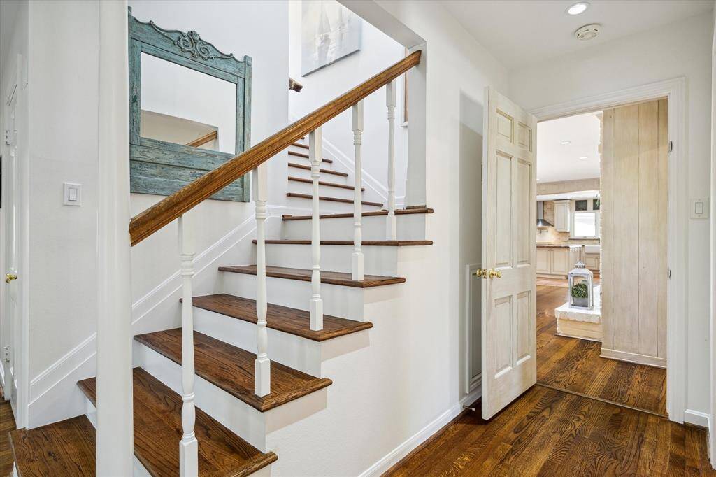 A graceful staircase leads to the upper-level suites and an additional study nook, ideal for working from home. Thoughtfully integrated storage beneath the stairs enhances practicality. This transitional space perfectly balances beauty and utility.