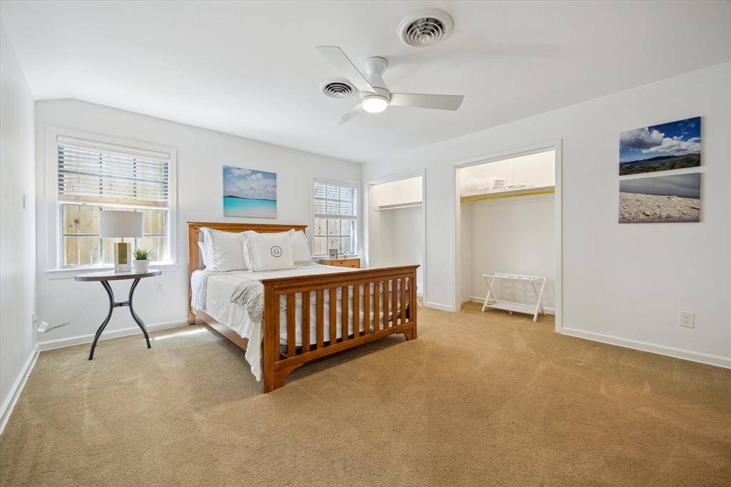 The guest house bedroom offers dual windows, dual closets, and plush carpeting underfoot. Perfect for long-term visitors or in-laws, it provides privacy and convenience. A tranquil space just steps from the main residence.