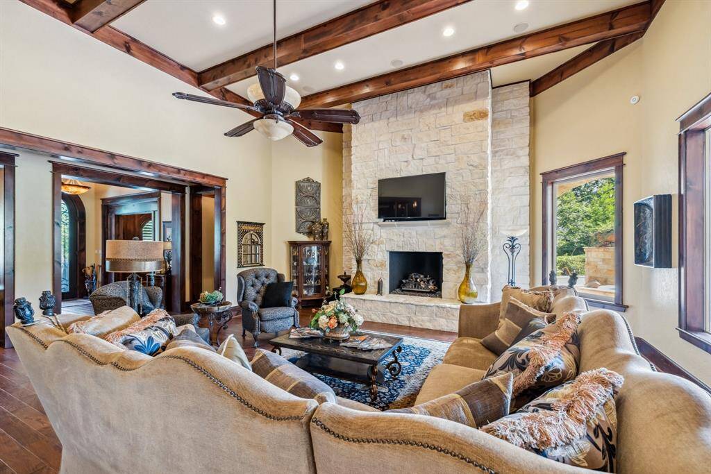 This kitchen features rich wooden custom cabinetry with elegant granite countertops, warm under-cabinet lighting, and a stylish tile backsplash. Convenient breakfast bar for those meals on the go helps to create a cozy, inviting atmosphere.