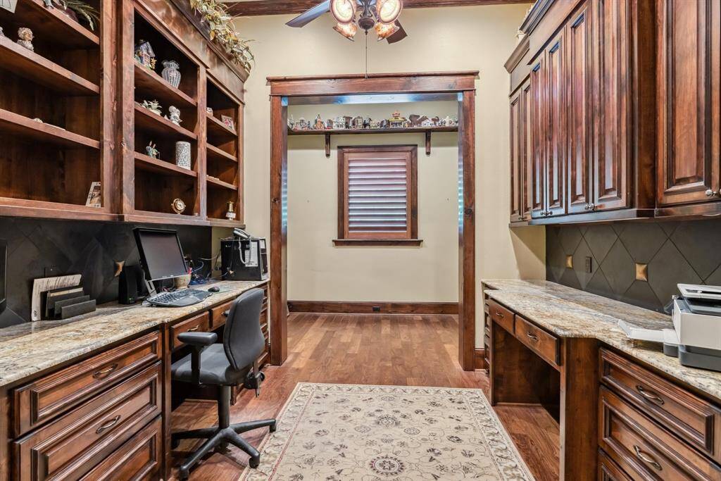 The secondary bedroom boasts an ensuite bath with a walk-in shower, granite counters, a stylish mirror, and plenty of storage.