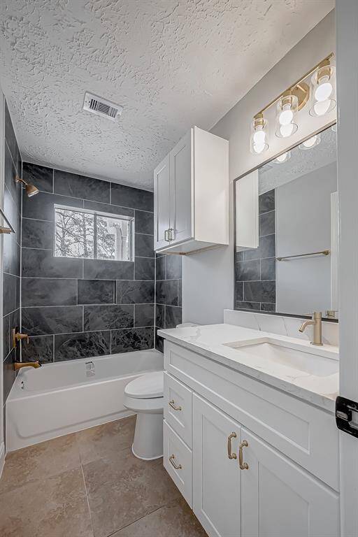The designer touches continue to the bathrooms: black tile tub surround, white shaker cabinets and gold accents.