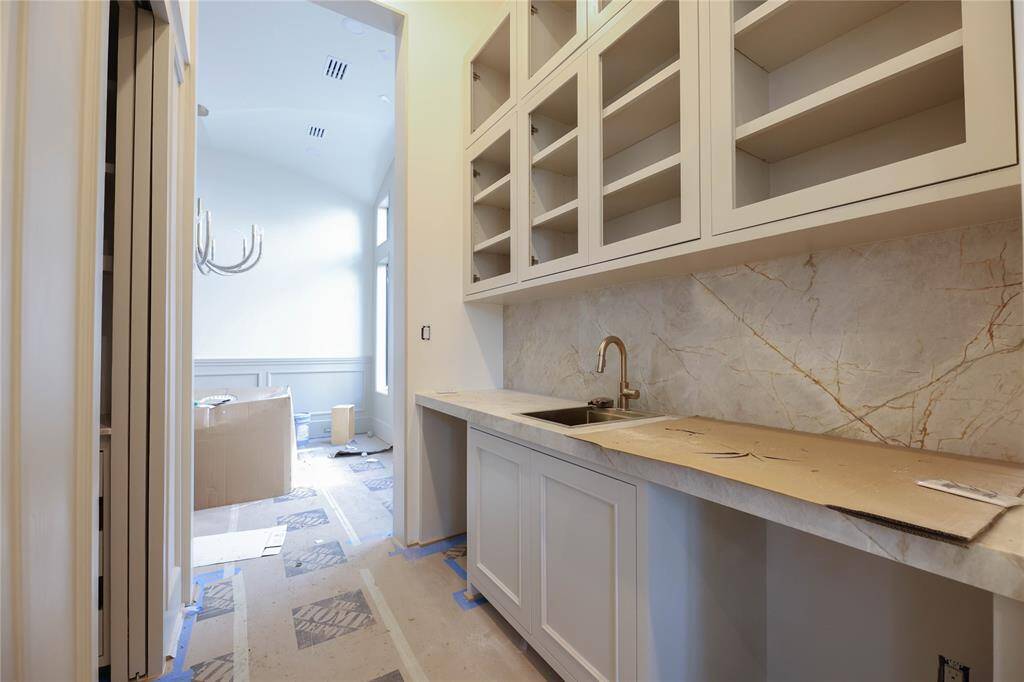 Butlers Pantry offers additional upper cabintry, built-in beverage & wine fridge, Taj Mahal counters & backsplash.